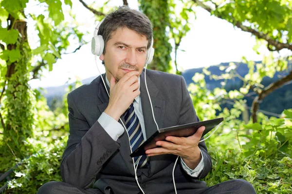 Pensive businessman with digital tablet, outdoors — Stock Photo, Image