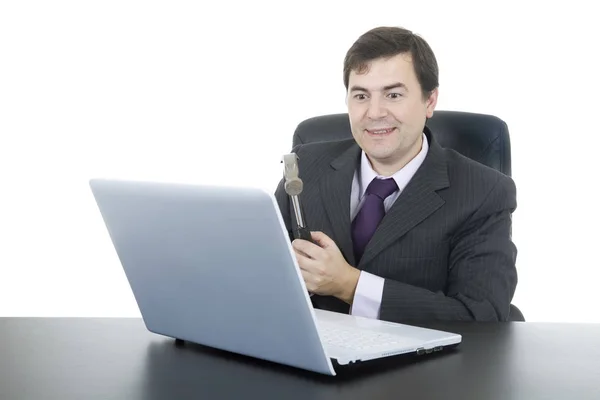 Felice uomo d'affari con un martello fracassare un computer portatile, isolato — Foto Stock