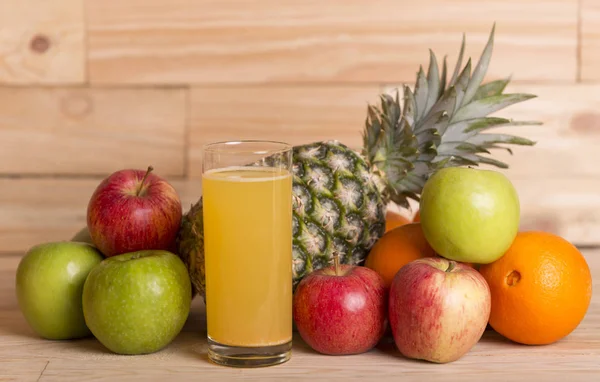 Mängd olika frukter och orange juice på ett träbord, studio bild — Stockfoto