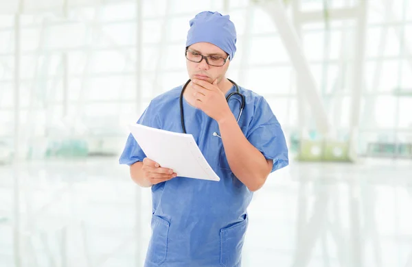 Médico preocupado mirando a sus notas, en el hospital — Foto de Stock