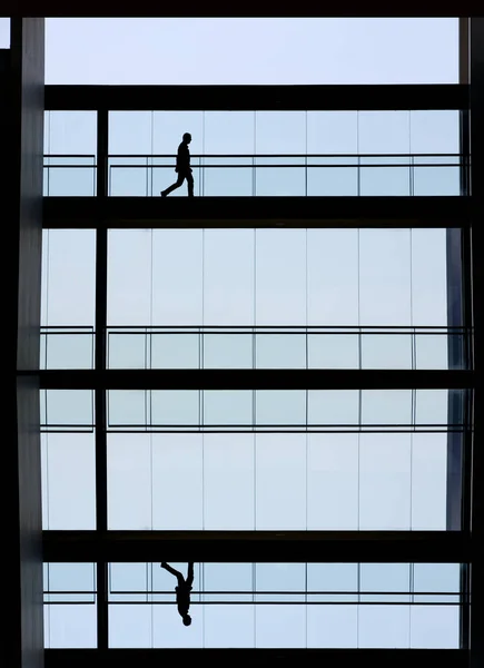 Προβολή σιλουέτα νεαρό επιχειρηματία σε ένα κτίριο γραφείων σύγχρονο εσωτερικό — Φωτογραφία Αρχείου