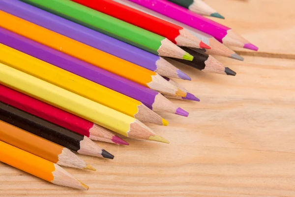 Dřevěné barevné tužky, na dřevěném stole — Stock fotografie