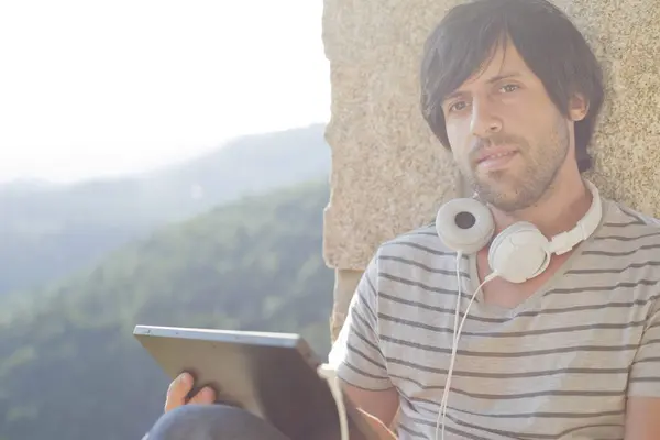 Uomo che lavora con un tablet pc ascoltare musica con le cuffie — Foto Stock