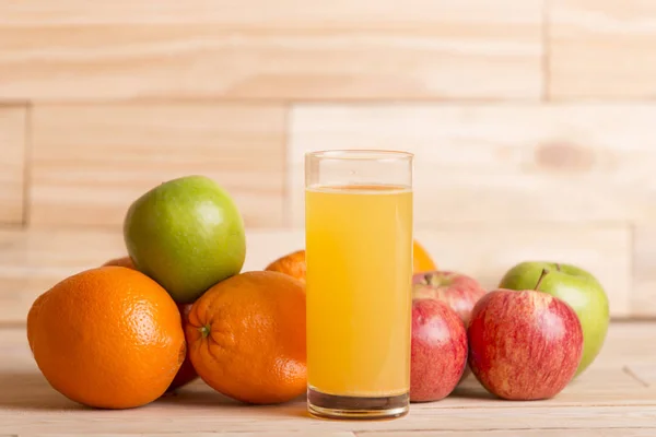 Různé ovoce a pomerančový džus na stole woden, studio obrázek — Stock fotografie