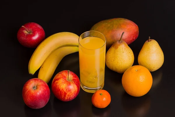 Разнообразие фруктов и апельсинового сока на черном фоне, студийное фото — стоковое фото