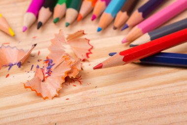 Ahşap masa üzerinde yontulmuş talaşlı ahşap renkli kalemler.