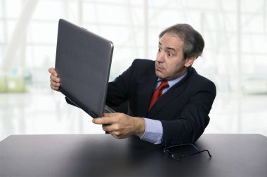onun laptop ile ofiste çalışan olgun iş adamı