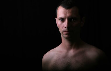 genç adam modelinde bir siyah arka plan ve çok düşük ışık