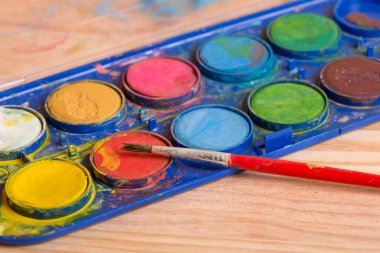 Ahşap arka planda boyalı kirli fırçalar.