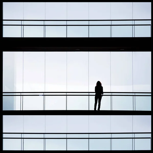 Vue en silhouette d'une jeune femme d'affaires dans un immeuble de bureaux moderne intérieur — Photo