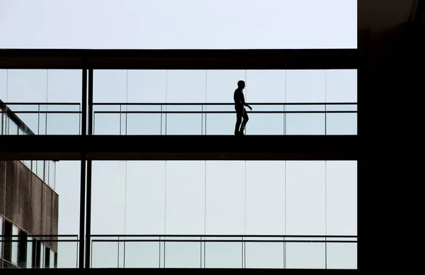 Bir modern ofis binası iç bir işadamı görünümünü siluet — Stok fotoğraf