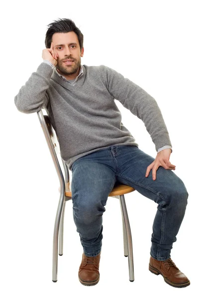 Glad casual man på en stol, isolerad på vit bakgrund — Stockfoto