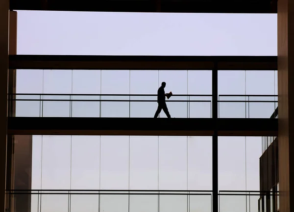 Vista silhueta de um jovem empresário num moderno edifício de escritórios interior — Fotografia de Stock