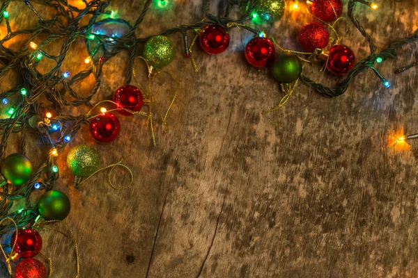 Decoración navideña con iluminación, sobre un antiguo fondo de madera — Foto de Stock