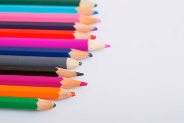 Bir beyaz kağıt üzerinde renkli ahşap kalemler