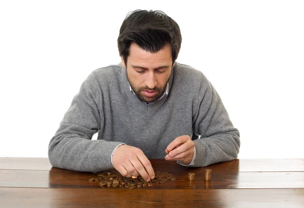 El hombre examina las monedas en un escritorio, aislado — Foto de Stock