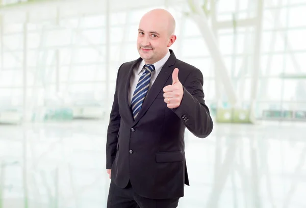 Молодой бизнесмен поднимает большой палец, в офисе — стоковое фото