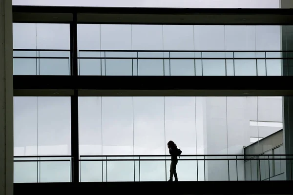 Vista silhueta de uma jovem empresária num moderno edifício de escritórios interior — Fotografia de Stock