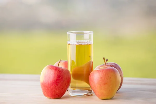 Apel dan jus apel di atas meja kayu, luar ruangan — Stok Foto