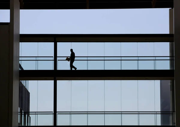 Silueta vista de un hombre de negocios en un moderno edificio de oficinas interior —  Fotos de Stock
