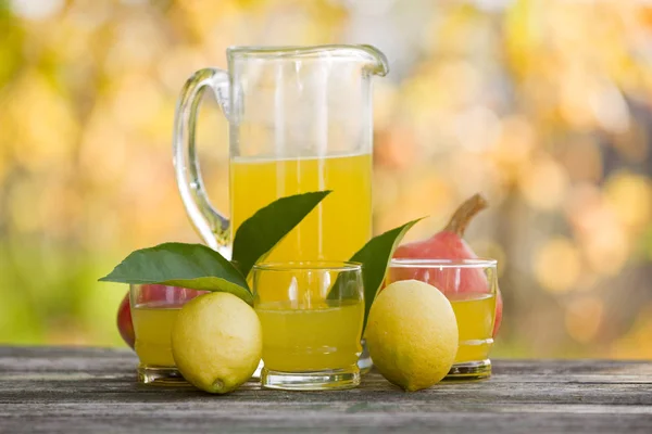 Zitronensaft auf Holztisch, Herbstset, draußen — Stockfoto