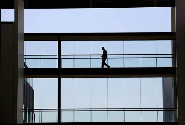 Vista silhueta de um homem de negócios em um moderno edifício de escritórios interior — Fotografia de Stock