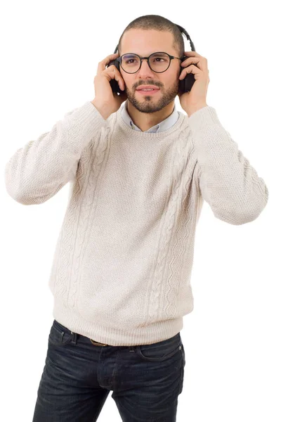 Dorywczo młody człowiek słuchania muzyki ze słuchawkami, na białym tle — Zdjęcie stockowe