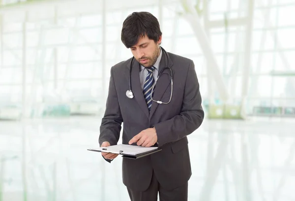 Manlig läkare tänker med sina anteckningar, på sjukhuset — Stockfoto