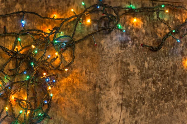 Decoración navideña con iluminación, sobre un antiguo fondo de madera — Foto de Stock