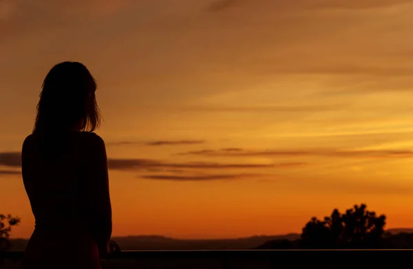 Vrouw uit de rug, kijken naar de zonsondergang — Stockfoto