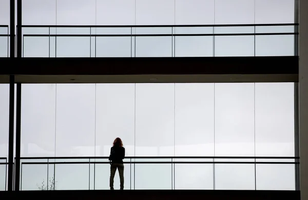 Vue en silhouette d'une jeune femme d'affaires dans un immeuble de bureaux moderne intérieur — Photo