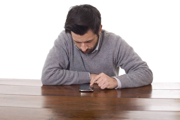 Worried casual man with a phone, on a desk, isolated — Stock Photo, Image