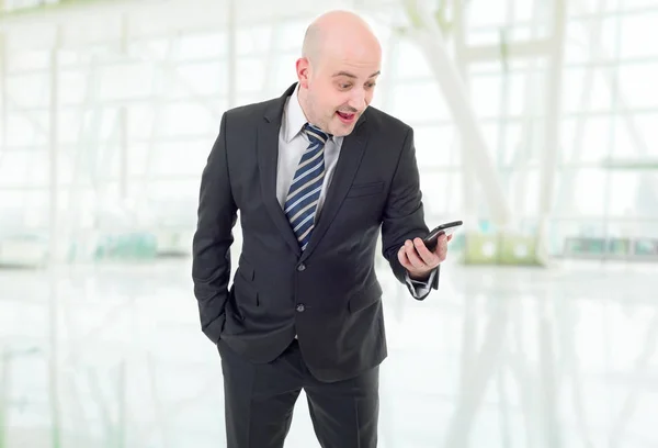 Der Geschäftsmann überraschte mit einem Handy. im Büro — Stockfoto