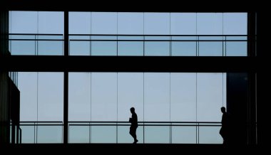 İki kişi bir modern ofis binası iç görünümünü siluet