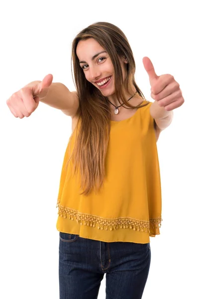 Young casual woman going thumbs up, isolated on white background — Stock Photo, Image