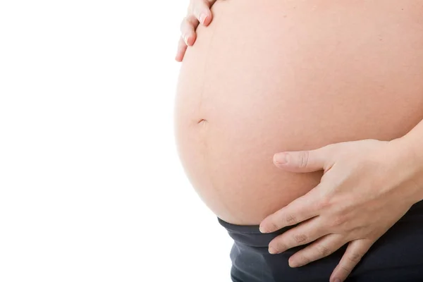 Nahaufnahme einer schwangeren Frau vor weißem Hintergrund — Stockfoto