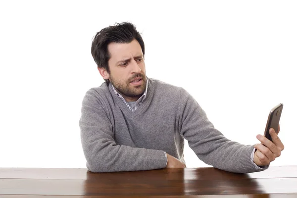 Homme décontracté avec un téléphone, sur un bureau, isolé — Photo