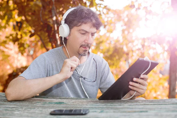 Muži, kteří pracují s počítači tablet pc, sluchátka, venkovní — Stock fotografie