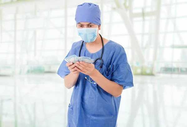 Happy male doctor holding bank notes, at the hospital — Stock Photo, Image