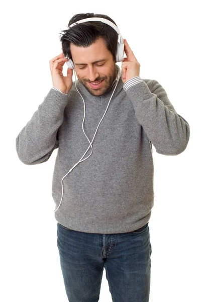 Casual jovem ouvindo música com fones de ouvido, isolado — Fotografia de Stock