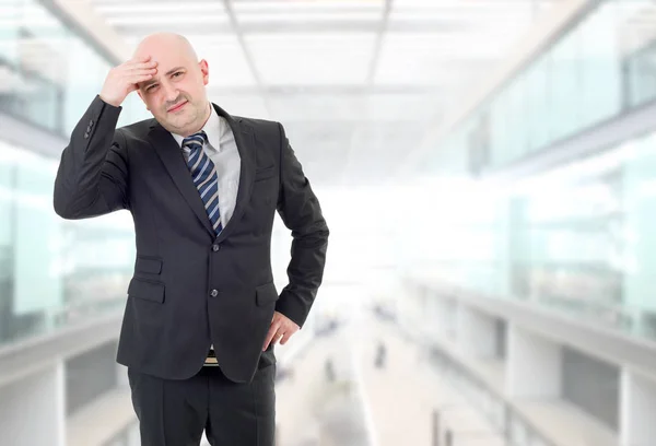 Geschäftsmann im Anzug gestikuliert mit Kopfschmerzen im Büro — Stockfoto