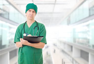 Erkek doktor, hastanede notlarıyla düşünüyor.