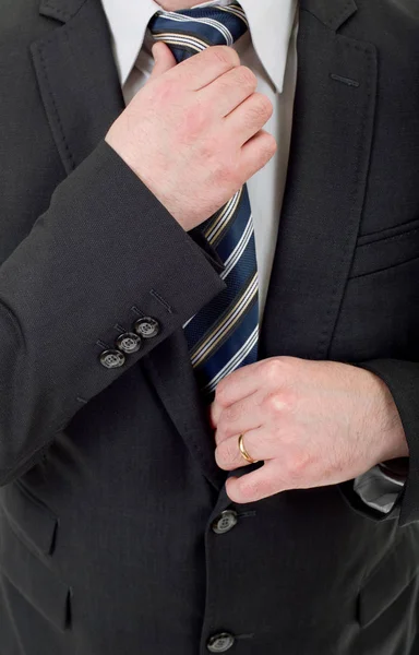 Hombre de negocios en traje negro ajustando corbata — Foto de Stock