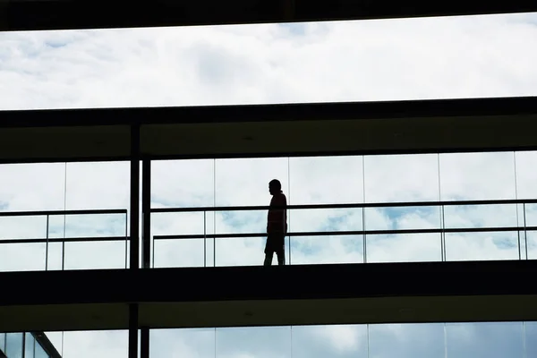 Vista silhueta de um jovem empresário num moderno edifício de escritórios interior — Fotografia de Stock