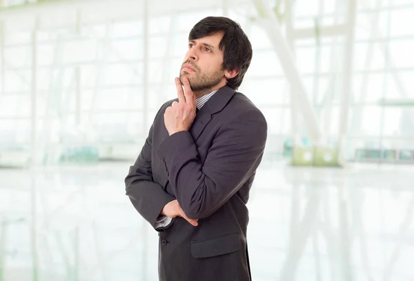 Young business man thinking, at the office — Stock Photo, Image