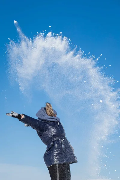 Girl throws snow into the sky Stock Picture