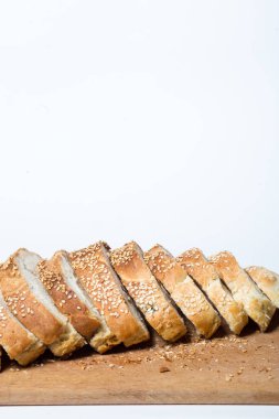 Beyaz arka planda beyaz ekmek. Mutfak tahtasında dilimlenmiş ekmek..
