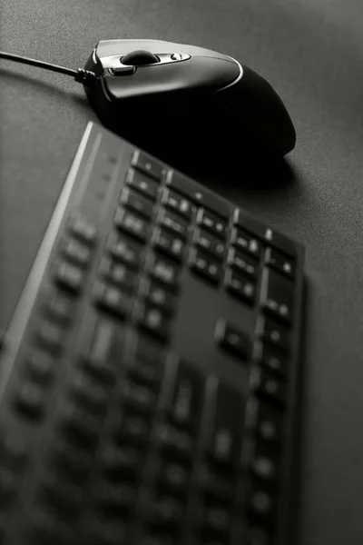 黑色游戏鼠标和键盘在黑色游戏鼠标垫上 — 图库照片