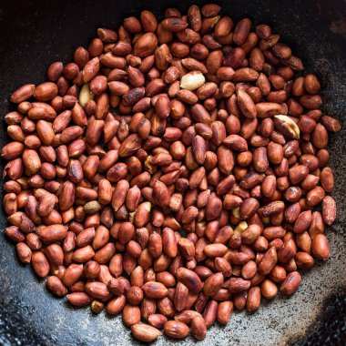 Eski metal bir tavada kavrulmuş fıstık, yukarıdan doğal ışık görüyor..