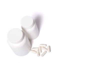 Beyaz arka planda izole edilmiş kapsüllü iki beyaz kap..